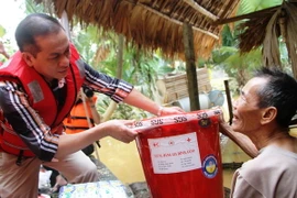 Trao quà hỗ trợ gia đình ông Dương Kim Danh, thôn Trung Thượng, xã Phương Mỹ, huyện Hương Khê, Hà Tĩnh. (Ảnh: Hoàng Ngà/TTXVN)