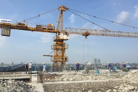 Công nhân đơn vị thi công đang khẩn trương phá dỡ bêtông tại tầng 19 tòa nhà 8B Lê Trực. (Ảnh: Mạnh Khánh/TTXVN)