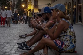 Người dân Cuba sử dụng dịch vụ WiFi công cộng trên một đường phố ở thủ đô La Habana. (Nguồn: AFP/TTXVN)