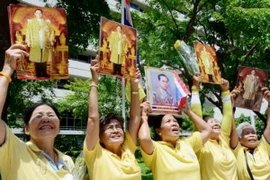 Người dân Thái Lan giơ cao chân dung Nhà Vua Bhumibol Adulyadej bên ngoài bệnh viện Siriraj ở Bangkok, nơi Nhà Vua đang nằm điều trị. (Nguồn: Kyodo/TTXVN)