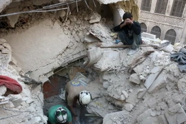Tình nguyện viên Syria tìm kiếm người bị mắc kẹt trong những đống đổ nát sau một vụ không kích tại Aleppo ngày 4/10. (Nguồn: AFP/TTXVN)