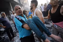 Chuyển người bị thương sau cuộc không kích của Israel xuống thị trấn Deir Al-Balah, Dải Gaza. (Ảnh: AFP/TTXVN)
