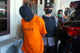 Cảnh sát Indonesia áp giải nghi phạm khủng bố tại Sorong, Indonesia. (Ảnh: AFP/TTXVN) 