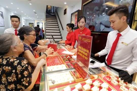 Khách mua bán vàng tại Công ty kinh doanh vàng bạc Mạnh Hải. (Ảnh: Trần Việt/TTXVN)