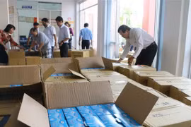 Công chức Sở Y tế tỉnh An Giang kiểm đếm, tiếp nhận số khẩu trang y tế từ Cục Hải quan tỉnh An Giang. (Ảnh: Công Mạo/TTXVN)