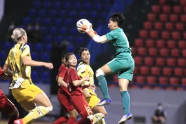 Thủ môn Đội tuyển nữ Việt Nam bắt gọn bóng trong chân cầu thủ Đội tuyển nữ Australia. (Ảnh: Thành Đạt/TTXVN)