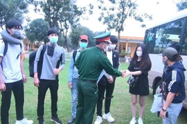 Các chiến sỹ Sư đoàn 390 - Quân đoàn 1 chia tay các công dân sau khi hoàn thành thời gian cách ly. (Ảnh: Khiếu Tư/TTXVN)