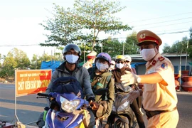 Lực lượng làm nhiệm vụ hướng dẫn người dân vào khai báo y tế cũng như thông tin về lịch trình di chuyển. (Ảnh: Thế Anh/TTXVN)