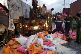 Nhiều bao gạo trên xe tải rơi xuống đường. (Ảnh: TTXVN phát)