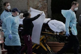 Nhân viên y tế chuyển bệnh nhân nhiễm COVD-19 lên xe cứu thương tại viện dưỡng lão Life Care Center ở Kirkland, bang Washington, Mỹ. (Ảnh: Reuters/TTXVN)