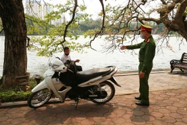 Công an quận Hoàn Kiếm đi kiểm tra, nhắc nhở nơi tập trung đông người tại Hồ Hoàn Kiếm. (Ảnh: Doãn Tấn/TTXVN)