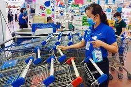 Nhân viên siêu thị Co.opmart vệ sinh, khử trùng xe đẩy hàng. (Ảnh: TTXVN phát)
