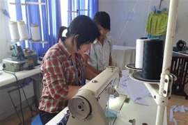Hướng dẫn cho học sinh học nghề may tại Nhà xã hội Long Hải. (Ảnh: Hoàng Nhị/TTXVN)