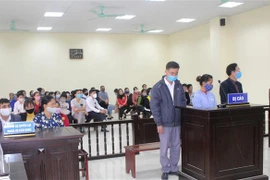 Các bị cáo và người dự đeo khẩu trang tại một phiên xét xử. (Ảnh: Nguyễn Nam/TTXVN)