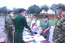 Các chiến sỹ Sư đoàn 390 - Quân đoàn 1 khẩn trương làm các thủ tục để công dân trở về địa phương. (Ảnh: Khiếu Tư/TTXVN)