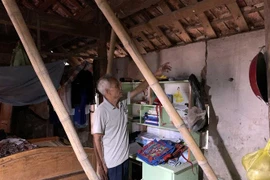 Nhiều nhà dân tại xóm 4 phải giữ nguyên hiện trạng hơn chục nằm qua do nằm trong diện giải phóng mặt bằng khiến nhà cửa xuống cấp, phải dùng tre để chống trước nguy cơ đổ sập. (Ảnh: Tá Chuyên/TTXVN)