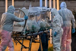 Nhân viên y tế chuyển bệnh nhân nhiễm COVID-19 tới bệnh viện ở Rome, Italy. (Ảnh: AFP/TTXVN)