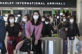 Hành khách đeo khẩu trang phòng lây nhiễm virus corona tại sân bay quốc tế Los Angeles ở California, Mỹ. (Ảnh: AFP/TTXVN)