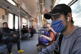 Người dân Ecuador đeo khẩu trang khi đi xe buýt. (Nguồn: AP)