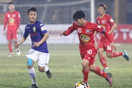 So với Quang Hải, Công Phượng (áo đỏ) đang không cho thấy sự tiến bộ. (Ảnh: Minh Chiến/Vietnam+)