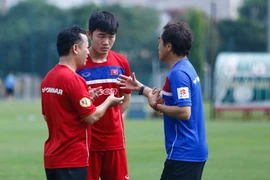 Xuân Trường trao đổi với trợ lý Hàn Quốc của ông Park Hang-seo bằng tiếng Anh. (Ảnh: Minh Chiến/Vietnam+)