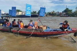 Vớt rác trên sông khu vực chợ nổi Cái Răng. (Ảnh: TTXVN phát)