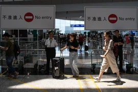 Hành khách làm thủ tục tại sân bay quốc tế Hong Kong. (Ảnh: AFP/TTXVN)