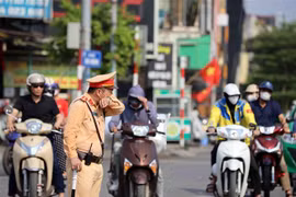 Ca trực từ 10-14 giờ mỗi ngày là ca trực mất sức nhất vì là thời gian nóng nhất trong ngày nhưng cán bộ, chiến sỹ Cảnh sát giao thông, Công an thành phố Hà Nội quyết tâm hoàn thành nhiệm vụ. (Ảnh: Phạm Kiên/TTXVN)