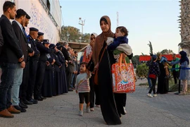 Người dân sơ tán khỏi Sudan tới cửa khẩu biên giới Rafah ở phía nam Dải Gaza. (Ảnh: THX/TTXVN)