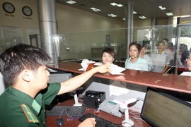 Bộ đội Biên phòng làm thủ tục nhập cảnh cho du khách Trung Quốc. (Ảnh: Trọng Đức/TTXVN)