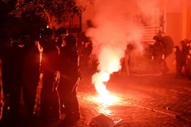 Cảnh sát phun hơi cay giải tán đám đông biểu tình quá khích tại Berlin. (Nguồn: EPA/TTXVN)
