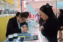 Khách hàng đang giao dịch vàng miếng. (Ảnh: Đức Duy/Vietnam+)