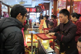 Khách hàng đang giao dịch vàng miếng tại Bảo Tín Minh Châu (Ảnh: Đức Duy/Vietnam+)