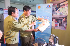Lực lượng Quản lý thị trường đang kiểm tra mã hàng hóa để xác định hàng vi phạm sở hữu trí tiệ. (Ảnh: Đức Duy/Vietnam+)