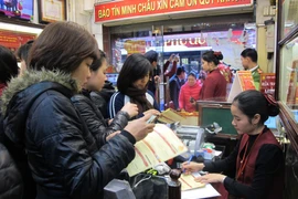 Khách hàng đang giao dịch vàng miếng tại Bảo Tín Minh Châu (Ảnh: Đức Duy/Vietnam+)