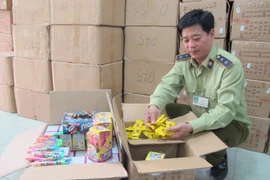 Cán bộ Đội Quản lý thị trường số 15 đang kiểm tra lô bánh kẹo nhập lậu từ Trung Quốc. (Ảnh: Đức Duy/Vietnam+)