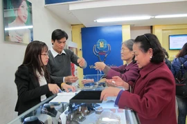 Khách hàng đang giao dịch vàng miếng. (Ảnh: PV/Vietnam+)