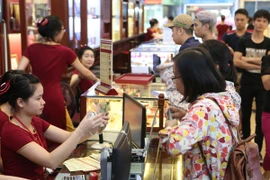 Khách hàng đang giao dịch vàng miếng. (Ảnh: PV/Vietnam+)