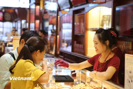 Khách hàng giao dịch vàng. (Ảnh: Vietnam+)