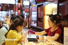 Khách hàng giao dịch vàng tại Hà Nội. (Ảnh: Đức Duy/Vietnam+)