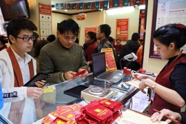 Khách hàng đang giao dịch vàng miếng. (Ảnh: Đức Duy/Vietnam+)