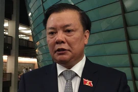 Bộ trưởng Đinh Tiến Dũng đang trao đổi với báo chí bên hành lang Quốc hội. (Ảnh: PV/Vietnam+)