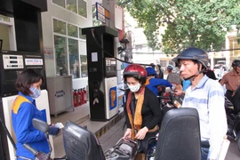 Nhân viên Petrolimex đang bán xăng cho khách hàng. (Ảnh: Đức Duy/Vietnam+)