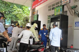 Nhân viên Petrolimex đang bơm xăng cho khách hàng (Ảnh: Đức Duy/Vietnam+)