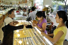 Khách hàng đang giao dịch vàng miếng. (Ảnh: TTXVN)