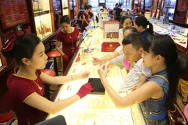 Nhân viên Bảo Tín Minh Châu đang giao dịch vàng miếng. (Ảnh: PV/Vietnam+)