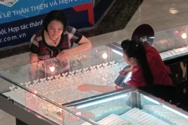 Khách hàng đang giao dịch vàng miếng. (Ảnh: Đức Duy/Vietnam+)