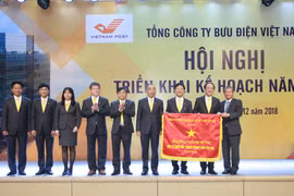 Thứ trưởng Bộ Thông tin và Truyền thông Nguyễn Thành Hưng (phải) thừa ủy quyền của Thủ tướng Chính phủ lên trao Cờ thi đua cho tập thể VietnamPost. (Nguồn: VNP) 