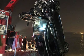 Lực lượng chức năng đã trục vớt được chiếc xe ôtô văng khỏi cầu Chương Dương vào sáng sớm 4/11. (Ảnh: PV/Vietnam+)