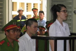 Hai bị cáo Đinh Nguyên Kha và Nguyễn Phương Uyên trước vành móng ngựa. (Ảnh: Thanh Bình/TTXVN)